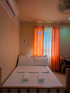 a large bed in a room with a window at Jenalfe Guest House in Camiguin