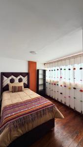 a bedroom with a large bed with lots of windows at Mayupata home in Cusco