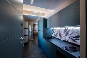 a bathroom with blue walls and a counter with a sink at Sibilla Suite - Manu Maison in Parma