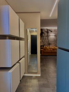 a kitchen with white cabinets and a living room at Sibilla Suite - Manu Maison in Parma