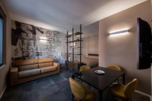 a living room with a couch and a table and chairs at Sibilla Suite - Manu Maison in Parma