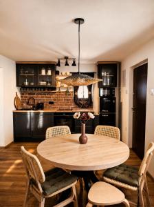 a kitchen and dining room with a wooden table and chairs at La Casa Kiara - Heated Pool, Jacuzzi & Forest View in Stubicke Toplice
