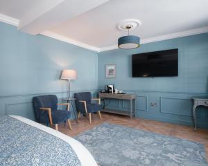 a hotel room with a bed and a tv on the wall at Lowcross House in Whitchurch