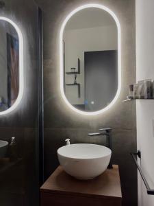 a bathroom with a sink and two round mirrors at Sibilla Suite - Manu Maison in Parma
