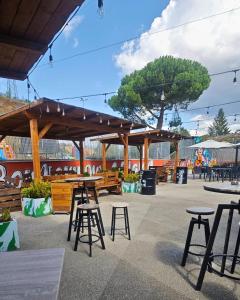 eine Terrasse mit Tischen und Stühlen und Holzkonstruktionen in der Unterkunft Bed&Harmony in Colleferro