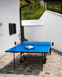 a blue ping pong table sitting on a patio at La Casa Kiara - Heated Pool, Jacuzzi & Forest View in Stubicke Toplice