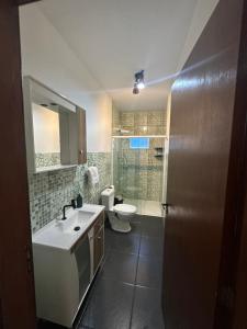 a bathroom with a sink and a toilet at Pousada Central Araquari in Araquari