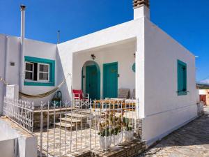 a white house with blue doors and a fence at Casa Spartines in Votsi