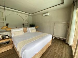 a bedroom with a large bed with white sheets at Cinze Villas and Hot Spring in Kubupenlokan