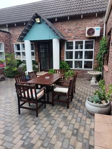 a wooden table and chairs on a patio at Bluewater Guesthouse in Port Elizabeth
