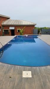 a large blue swimming pool in front of a house at Boripe Hotel And Suites, Oluponna, Osun State in Olupona