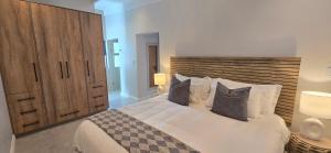 a bedroom with a large white bed with two pillows at Sky & Sea in St. Helena Bay
