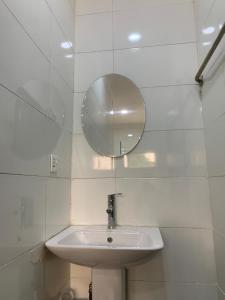 a white bathroom with a sink and a mirror at Kris Courts in Ibadan