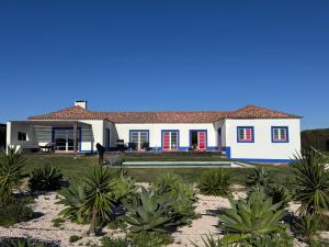 a white house with a horse in front of it at Quinta Maria Cotovia in Porto Covo