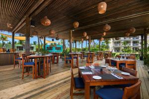 a restaurant with wooden tables and chairs on a deck at Alexandra Resort - All-Inclusive in Providenciales