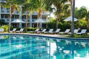 a swimming pool with chaise lounge chairs and a hotel at Alexandra Resort - All-Inclusive in Providenciales