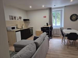 a living room with a couch and a kitchen at Doré in Carhaix-Plouguer
