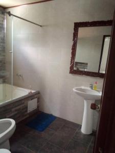 a bathroom with a sink and a toilet and a tub at Hotel Nayarith in Acacías