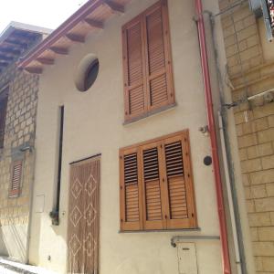 a house with wooden shutters and a door at A Ciciredda in Barrafranca