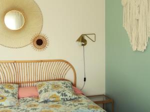 a bedroom with a bed and a mirror on the wall at Vagabondes - Chambres d'hôtes à Azay-Le-Rideau in Azay-le-Rideau