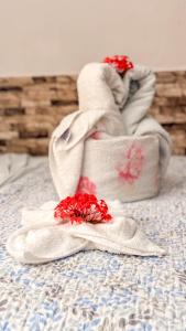 two towels on a bed with red flowers on them at Pousada Timbalada in Morro de São Paulo +41 photos