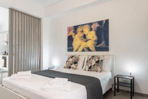 a bedroom with two beds and a painting on the wall at Il Cortile Holiday House in Caccamo