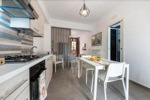 a kitchen with a table and chairs and a stove at Il Cortile Holiday House in Caccamo