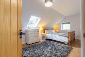 a bedroom with a bed and a dresser and a window at The Roost in Wendling
