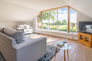 a living room with a couch and a large window at The Roost in Wendling