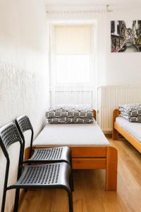 a room with a bed and a bench and a window at Kwatery Fado in Częstochowa