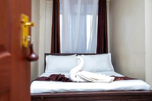 a bed with a white swan sitting on top of it at ST Augustine Hotel Ltd in Kisumu