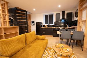 a living room with a couch and a kitchen at La Bulle Prestige in Montargis