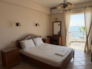 a bedroom with a bed with a view of the ocean at Vythos Rooms in Paralio Astros