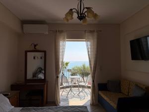 a living room with a view of a balcony at Vythos Rooms in Paralio Astros