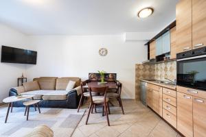 a kitchen and living room with a table and a couch at Verde Mar Apartment in Tivat