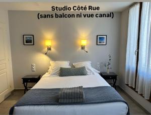 a bedroom with a large white bed with two tables at Le Petit Bijou Sète, 5 appartements in Sète