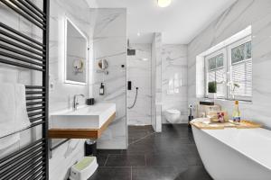 a white bathroom with a sink and a shower at JUNIPRO Luxury Apartments in Bosen-Eckelhausen +63 photos