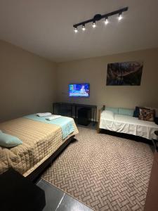 a bedroom with two beds and a flat screen tv at Pousada Central Araquari in Araquari
