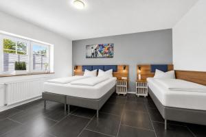 two beds and a couch in a room at JUNIPRO Luxury Apartments in Bosen-Eckelhausen