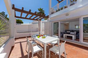 a patio with a white table and chairs on a balcony at AlmeriaSuite Mojacar Breeze Apartments in Mojácar