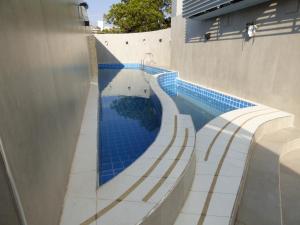 a swimming pool with blue tiles on the side of a building at OSHO Hotel in Santa Cruz de la Sierra