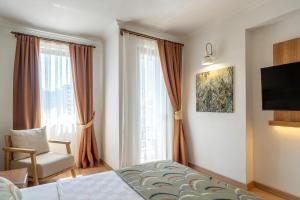 a bedroom with a bed and a chair and windows at La Brisa Hotel in Antalya