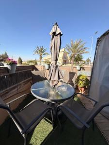 a table and chairs on a patio with an umbrella at ARAD-DEAD SEA BASHIRIS PLACE in Arad