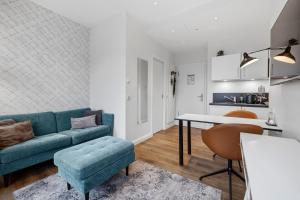 a living room with a blue couch and a table at Nena Apartments Bremen by LESA in Bremen