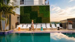 a woman walking next to a swimming pool at Circ Hotel in Hollywood