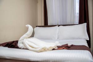 a bed with white sheets and pillows in a room at ST Augustine Hotel Ltd in Kisumu