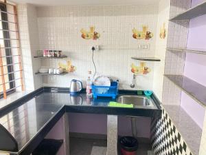 a kitchen with a sink and a counter top at R J Homestay in Māvalli