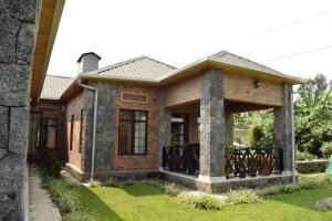 a small brick house with a porch at Mrëmbo Boutik Hôtel in Ruhengeri