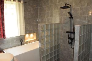 a bathroom with a shower with a tub and a sink at Mrëmbo Boutik Hôtel in Ruhengeri +31 photos