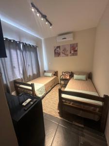 a room with two beds and a tv in it at Pousada Central Araquari in Araquari